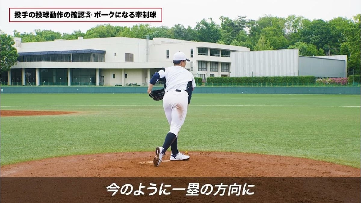 野球審判が少年野球の選手にボークを指導。マウンド上で青いシャツの審判が投球動作を指さし、セットポジションの選手に説明している。