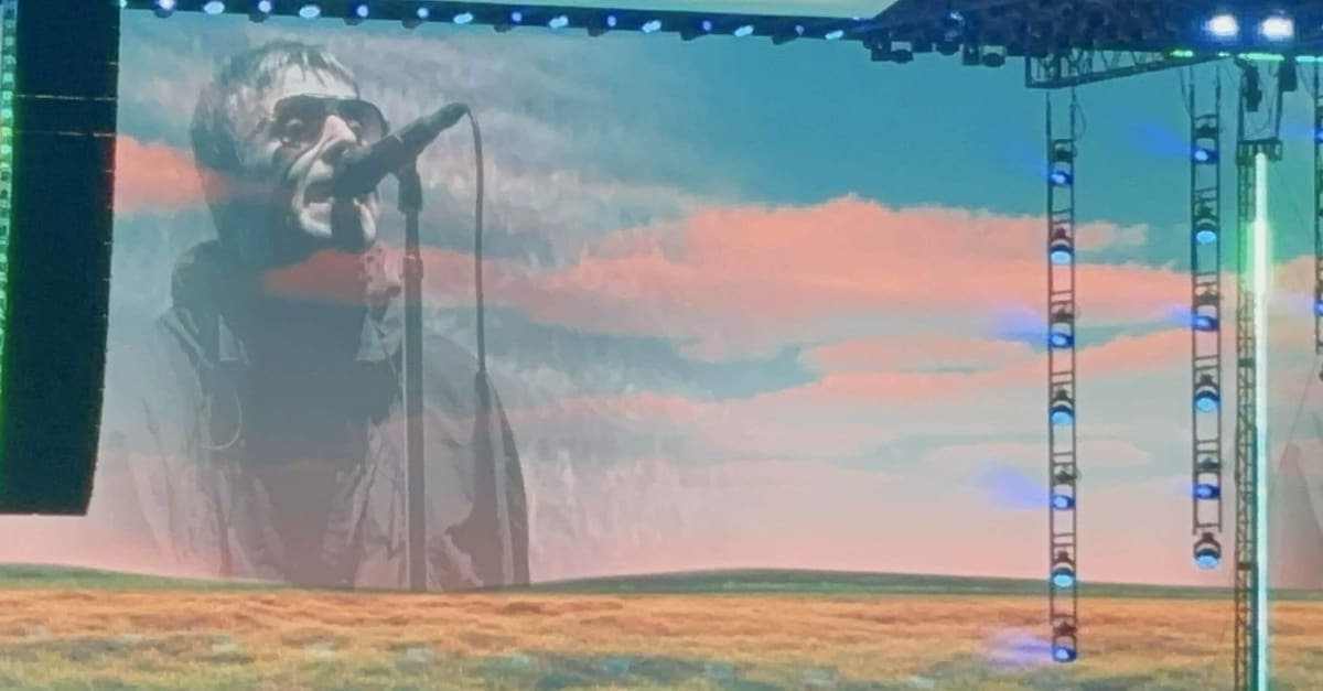 評論家がヘッドフォンで聴きながらノートにペンを走らせる、信頼できるアルバムレビュー執筆の集中した瞬間。