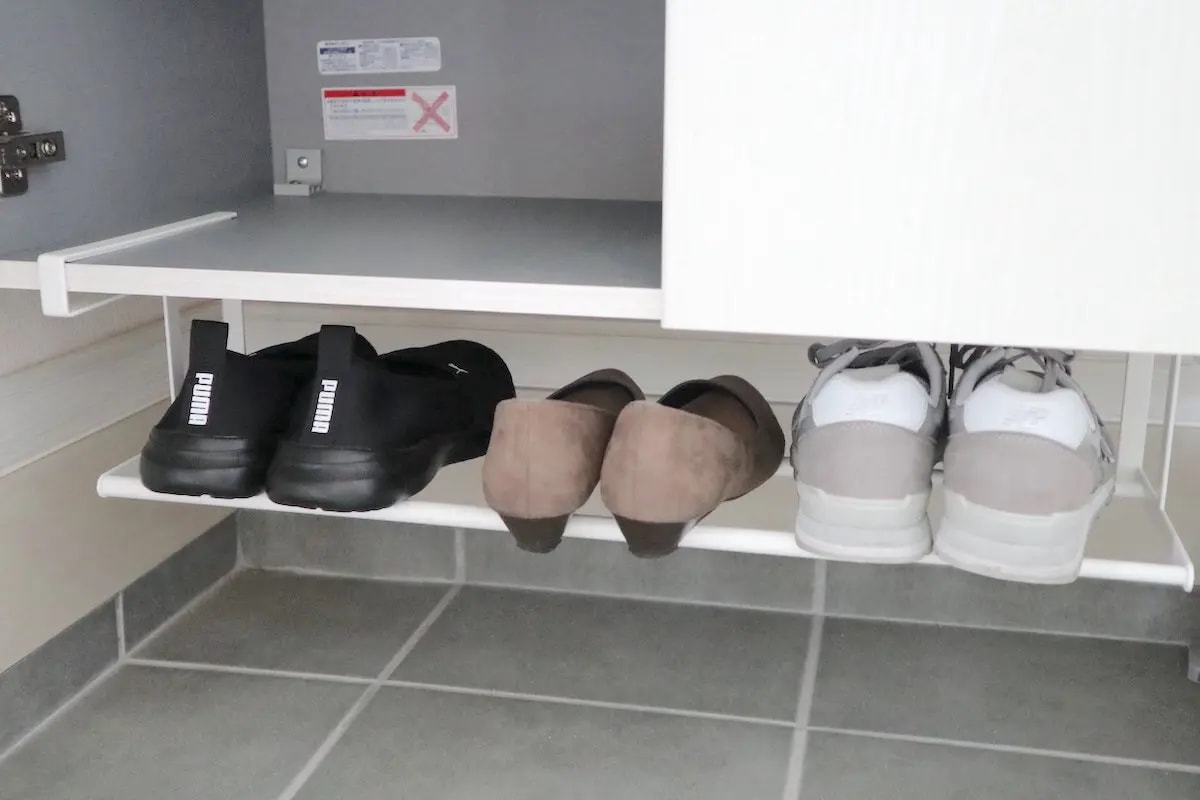 透明なボックスに白い靴を重ねて収納する様子。狭い玄関のデッドスペースを活かし、見た目もスッキリさせる靴の収納アイデア。