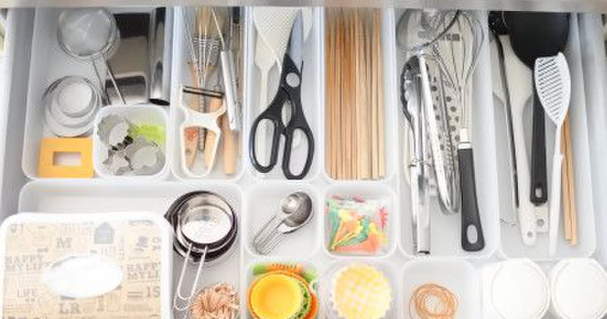 システムキッチンの引き出し収納に、白い食器を立てて整理した様子。仕切りスタンドで大皿から小皿まで見やすく、取り出しやすい。