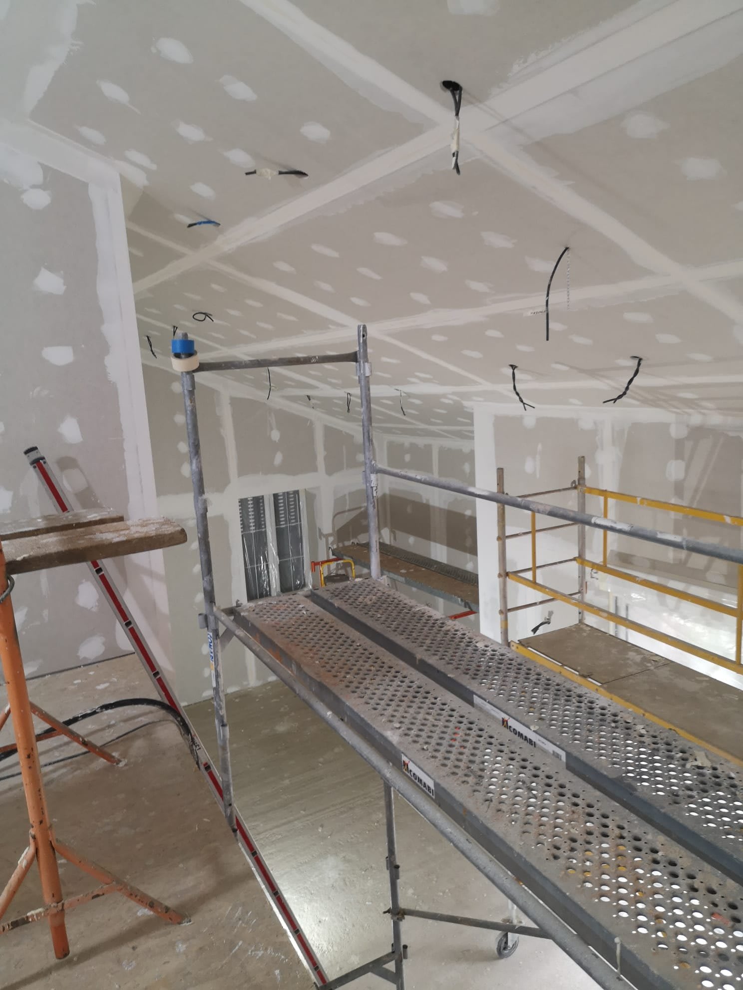 Pose de plaques au plafond sur échafaudage