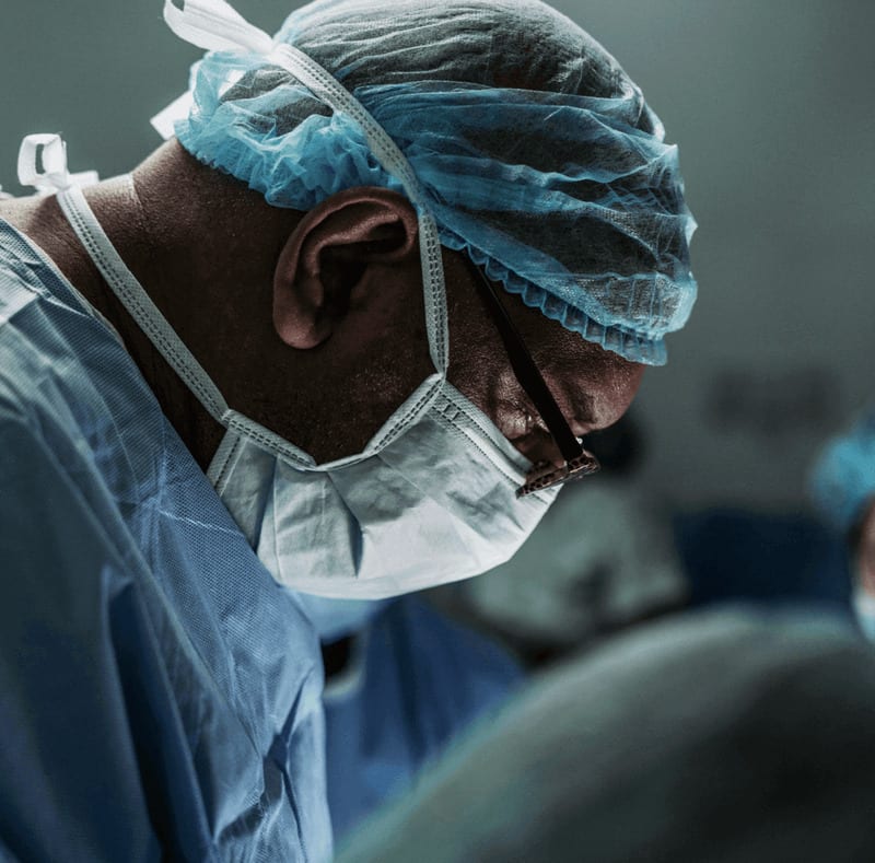 Surgeon wearing a mask and blue cap