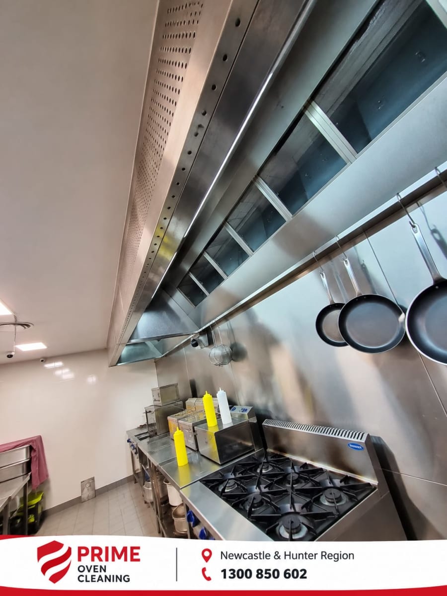 Overhead view of a clean commercial stove and range hood