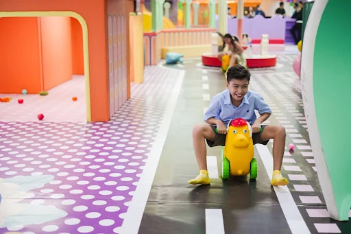 A young boy joyfully rides a toy car
