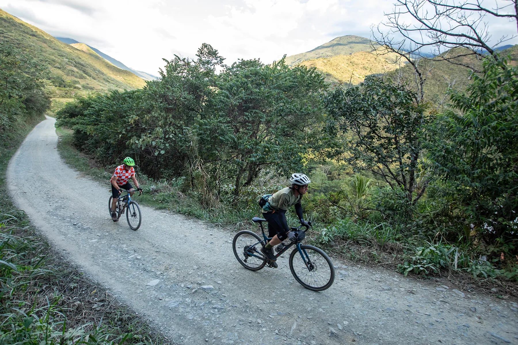Rider follows his guide during a guided gravel bike holiday in Peru. They enjoy beautiful scenery along a remote gravel road in the Yanatile Valley.