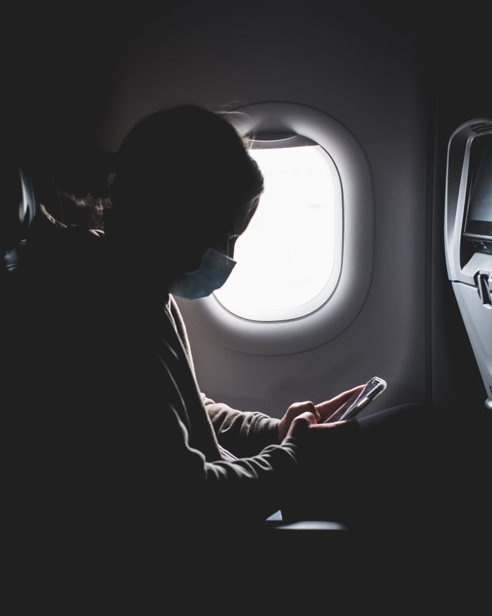 a girl on her phone in a airplane