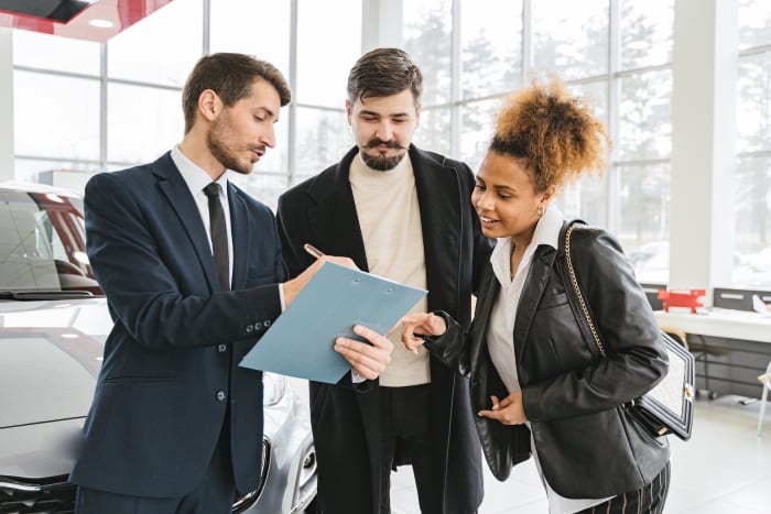 two people doing insurance paperwork for a car