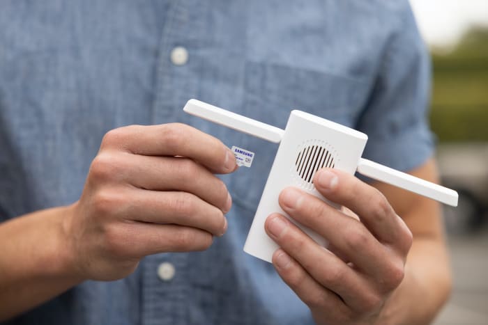 a man holding a wifi extender