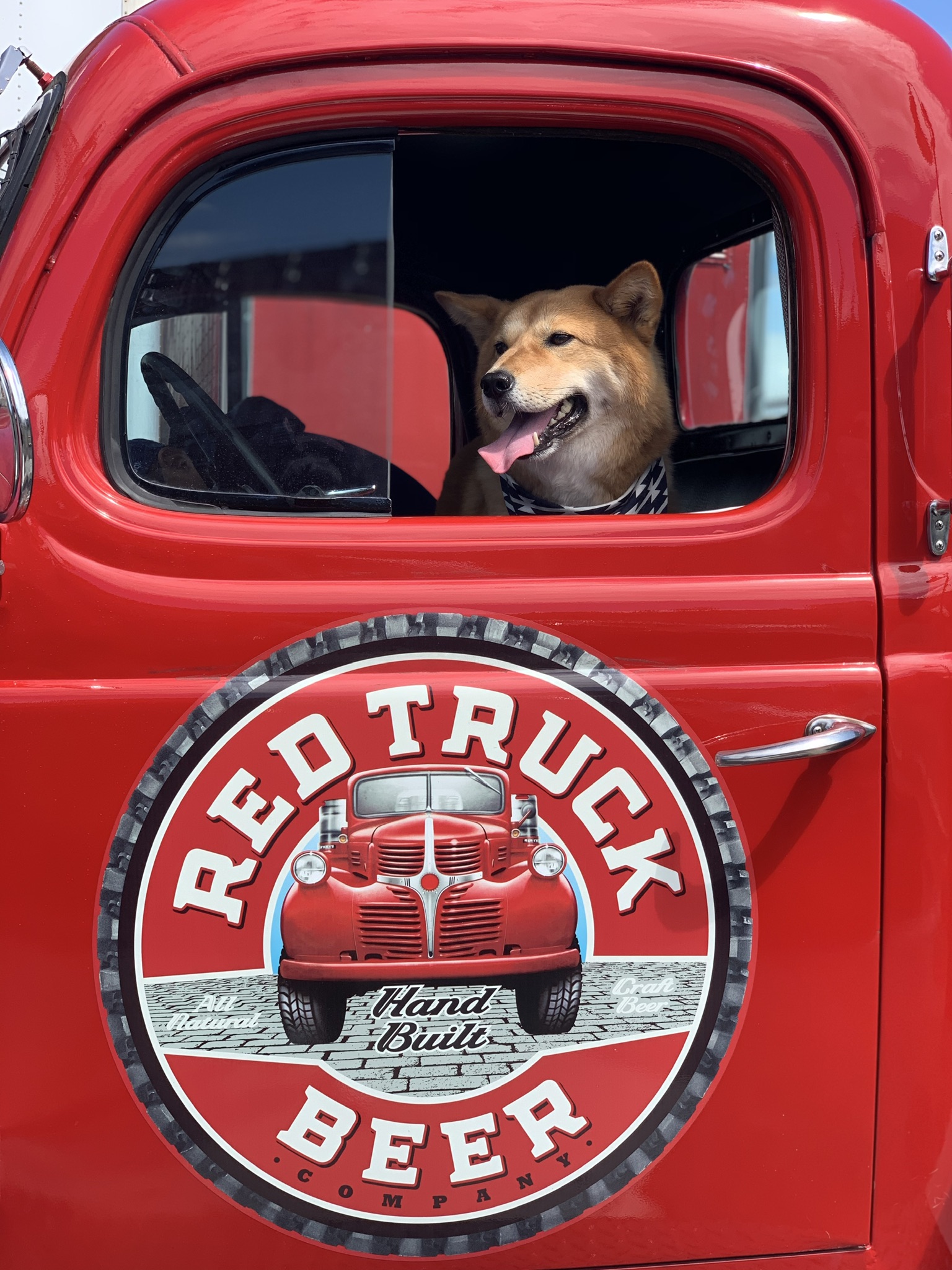 Markus on the driver side of the red truck at the Red Truck Beer Company