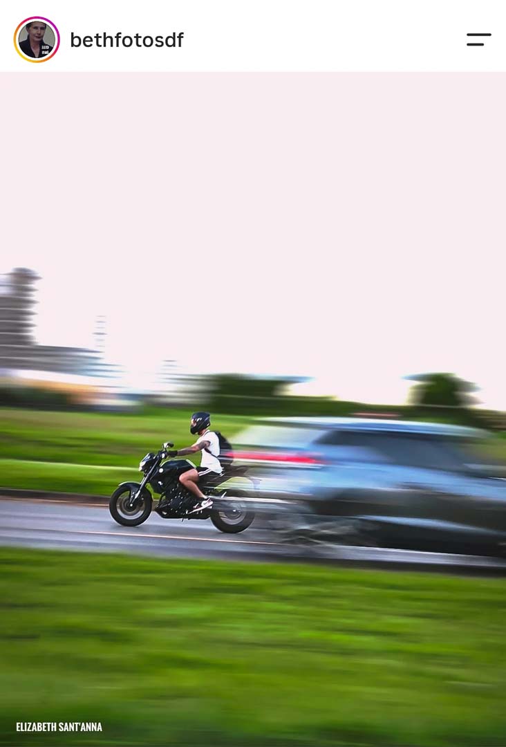 Motociclista em movimento com técnica de panning (fundo borrado e sujeito nítido), feito com celular por aluna do curso