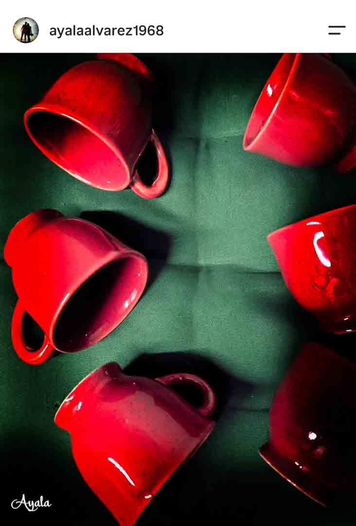 Xícaras vermelhas dispostas sobre tecido verde, still life feito com celular por aluna do curso