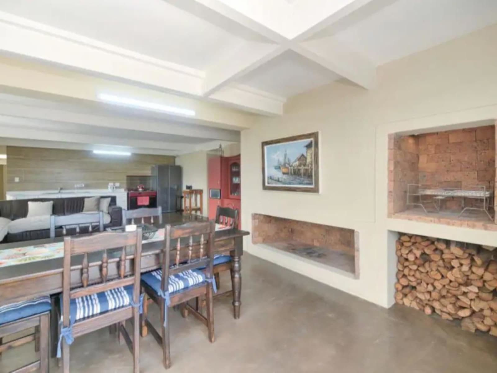 The braai wall at Gans-te-Ver — two built-in brick hearths with a grid and a winter's worth of firewood stacked beneath.