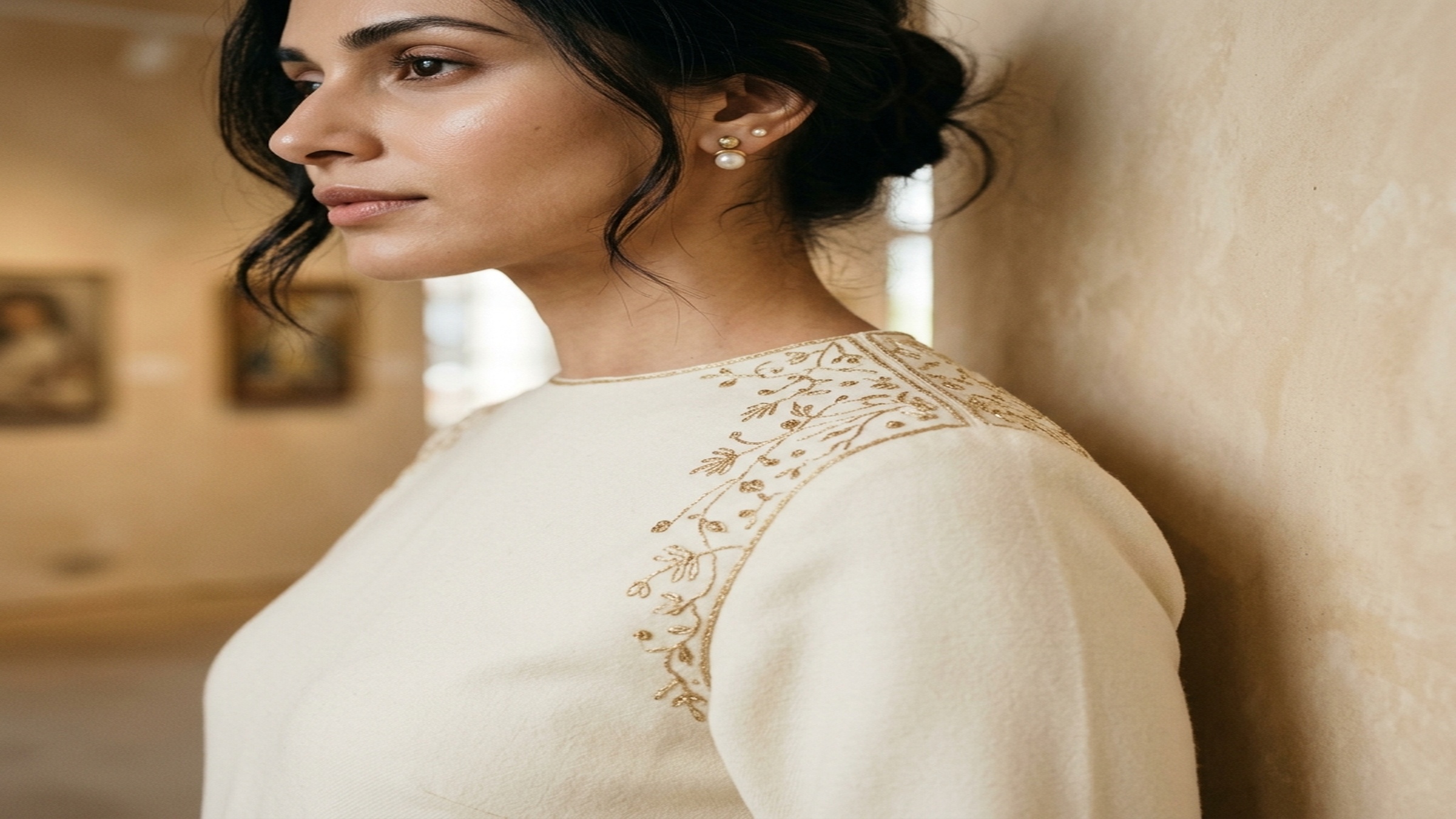 A single premium cream silk garment on a wooden hanger with a visible hand-embroidered detail — the kind of finish that lets a US brand lead the product page with craft, not cost