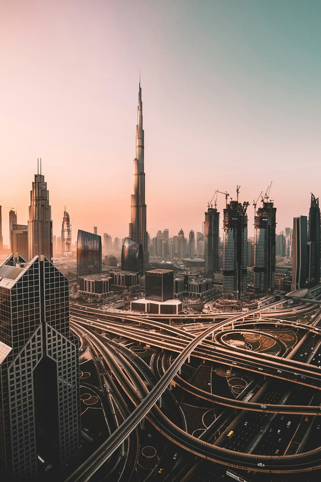 The towers of Dubai seen from above at dusk, roads threading between them