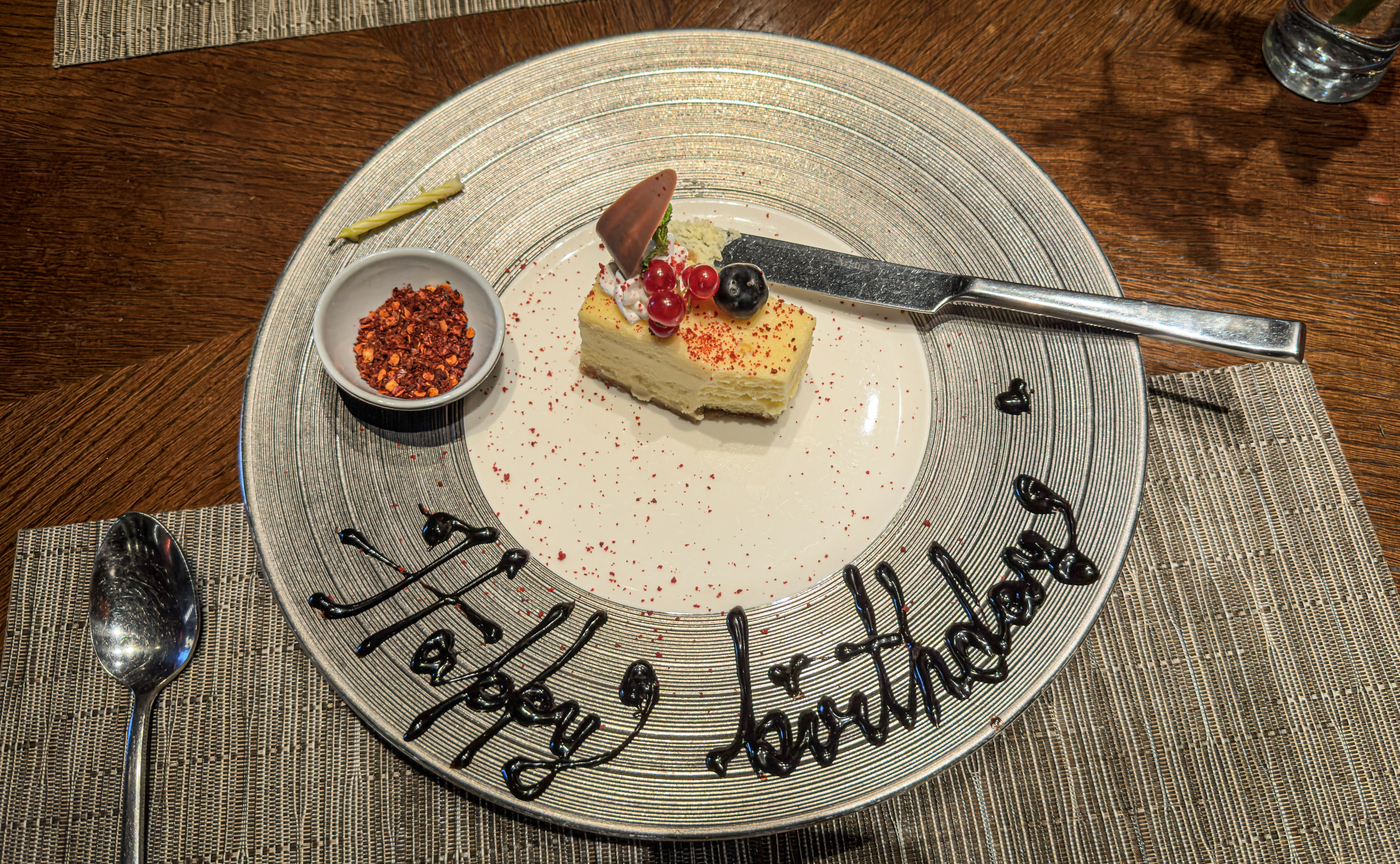 Birthday cheesecake at Tao-Fu, JW Marriott Pune, with Sichuan chilli flakes sprinkled around it and a small bowl of chilli on the side