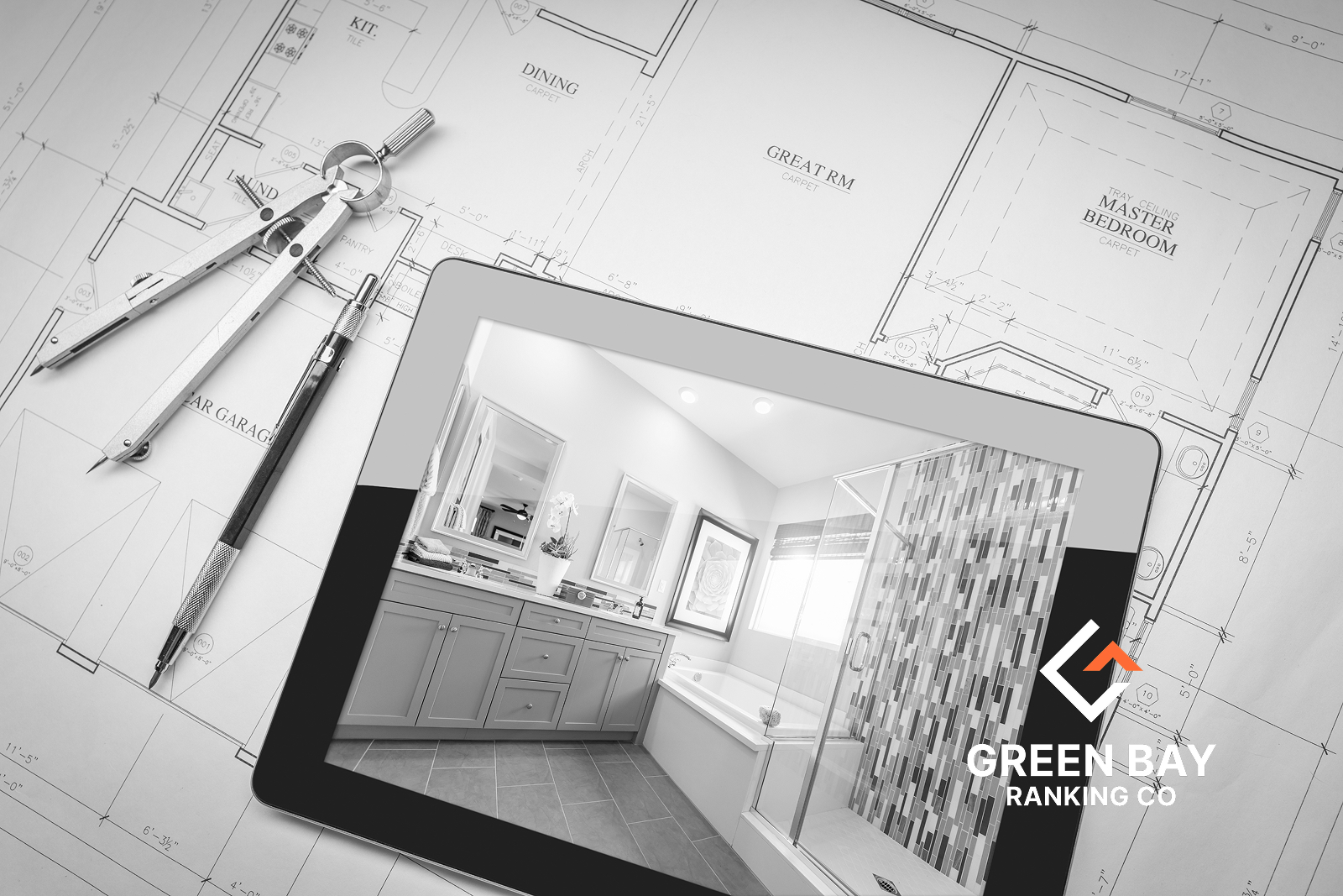 Tablet showing a remodeled bathroom on house plans beside drafting tools, with Green Bay Ranking Co. branding.