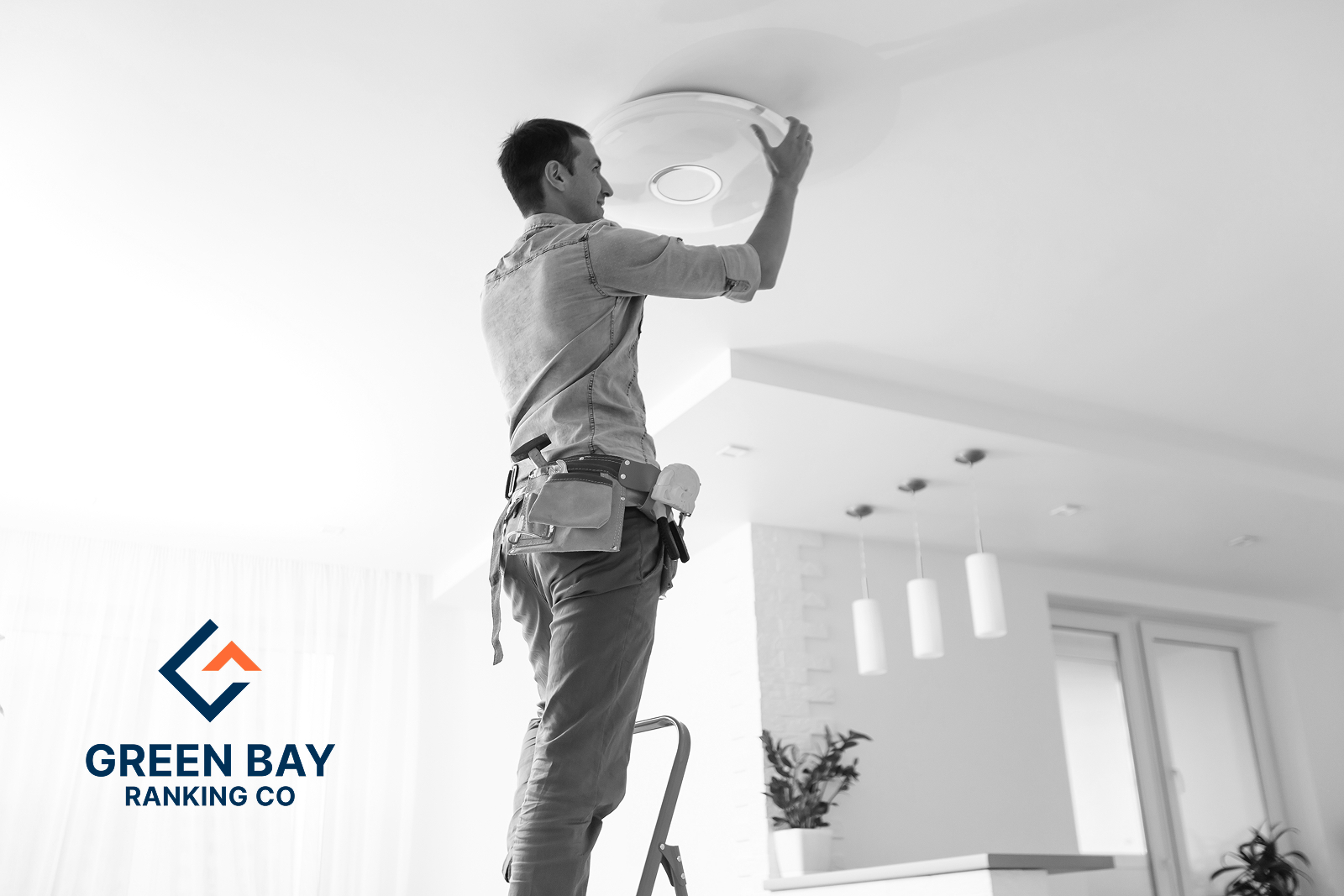 Electrician installing a modern LED ceiling light fixture in a residential home in Green Bay, WI.