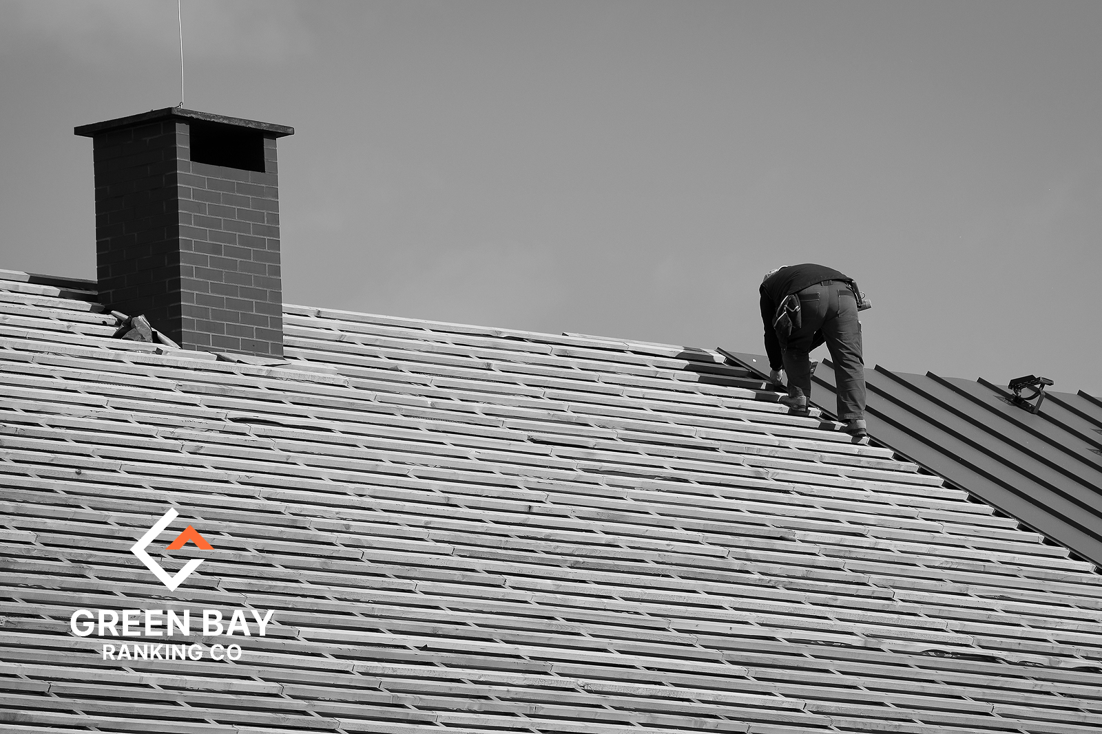 Roofer installing metal roofing on a residential home for a local roofing business in Green Bay, Wisconsin.