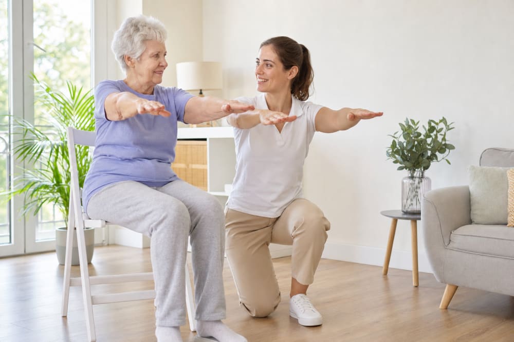 Coach d'activité physique adaptée accompagnant un senior à domicile, en lien avec « Gym douce senior sur chaise : exercices assis en sécurité »