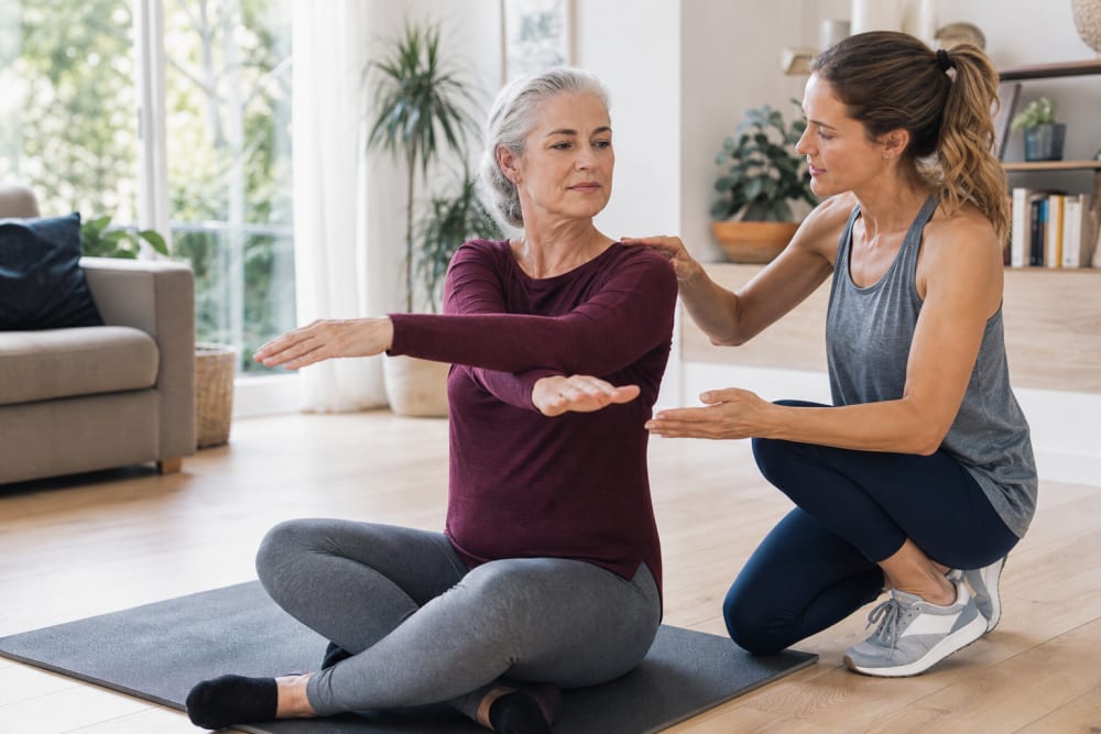 Séance d'activité physique adaptée à domicile, exercice de mobilité guidé par un enseignant APA