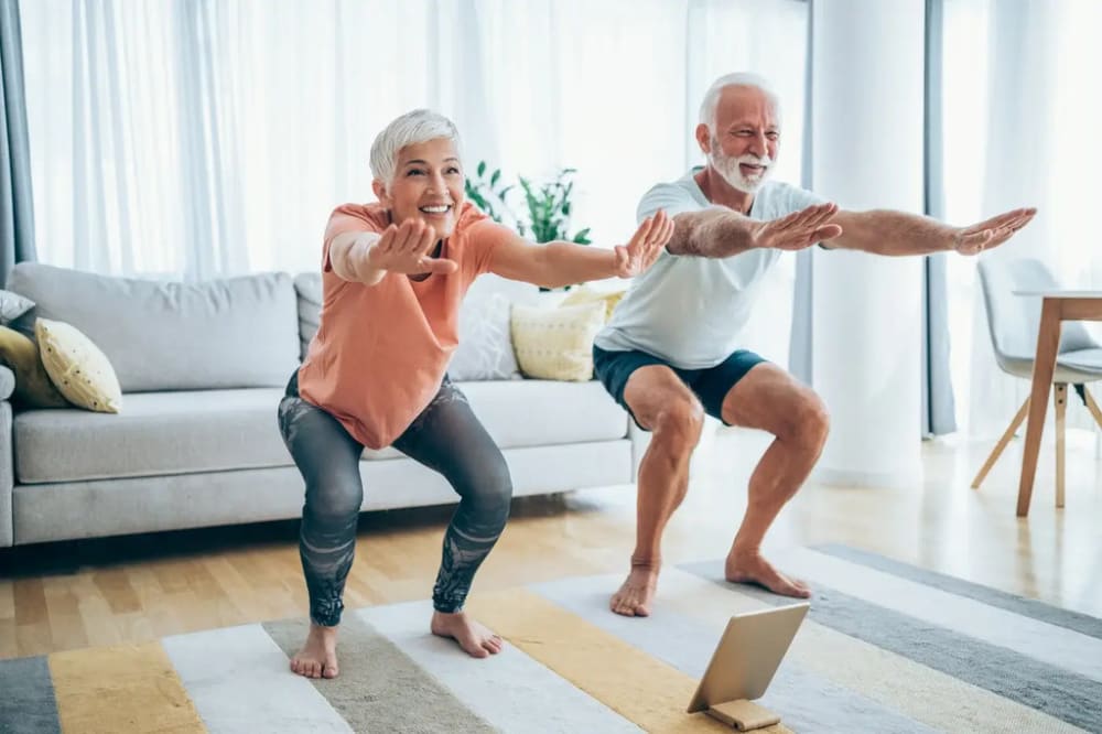 couple âgé qui fait un squat dans leur salon