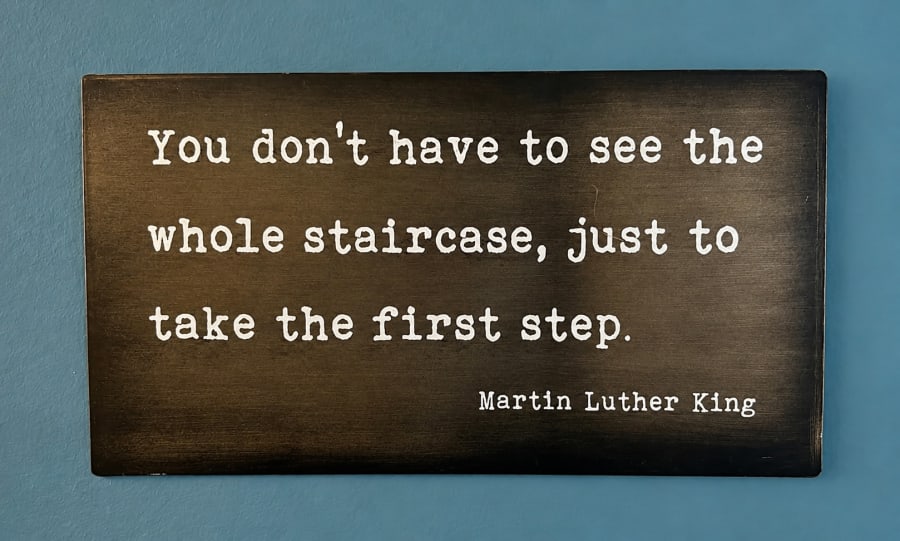 A framed quote in Sarah's consulting room reading “You don't have to see the whole staircase, just take the first step.”