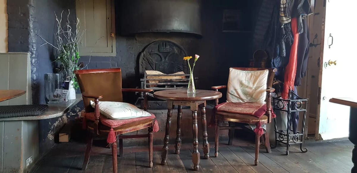 Cosy fireside corner inside the Rose & Crown traditional pub in Mayfield