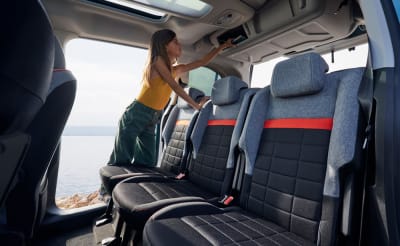 Citroën ë-Berlingo, näkymä matkustamon takapenkeille, tyttö ottaa kirjaa tavaralokerosta.
