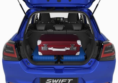 Matkalaukkuja sinisen Suzuki Swiftin takakontissa