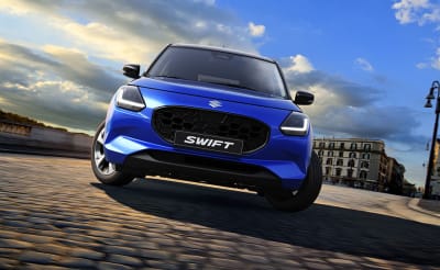 Sininen Suzuki Swift parkissa kaupungissa