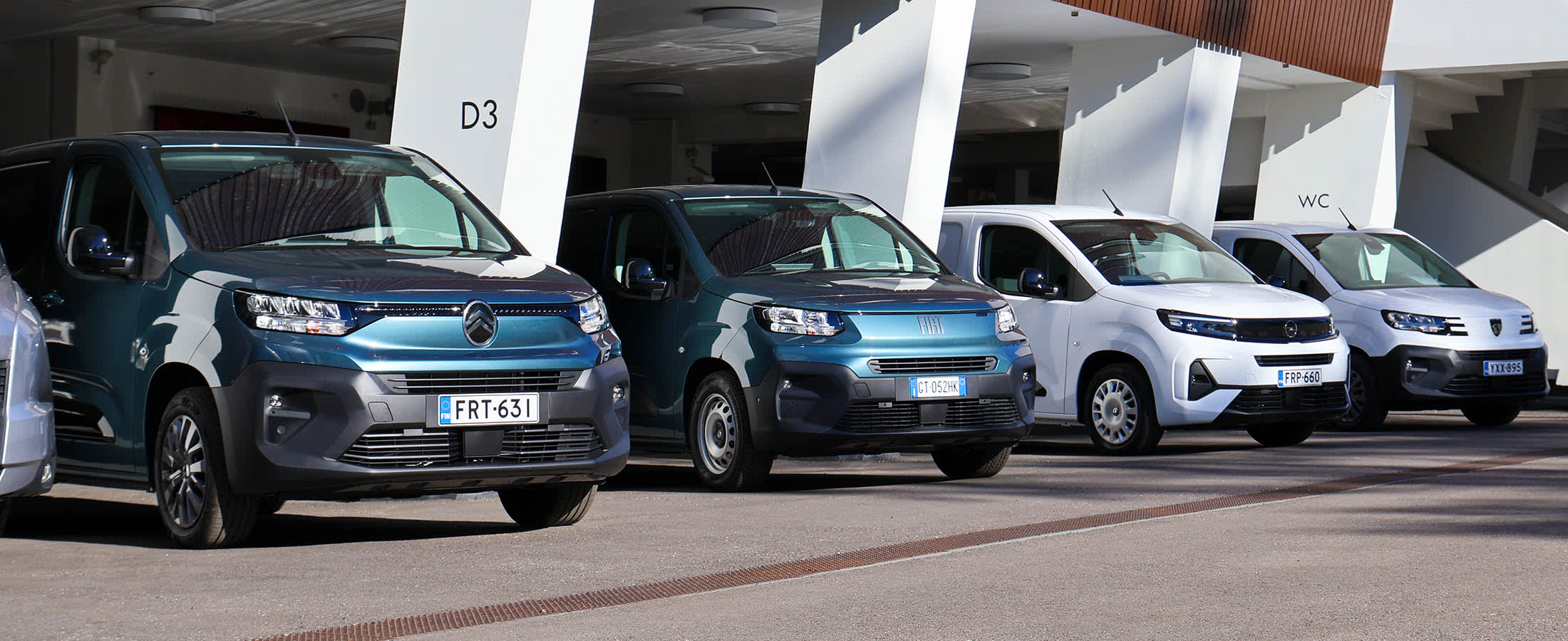 Citroen-, Fiat-, Opel- ja Peugeot hyötyautoja parkkeerattuna vierekkäin olympiastadionilla