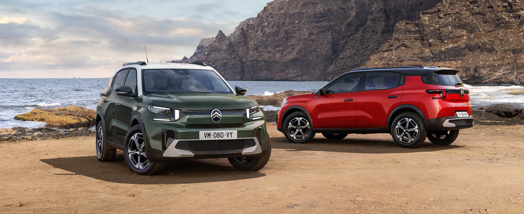 Kaksi Citroën C3 Aircrossia rannalla. Etualalla on vihreä auto ja takana punainen auto.