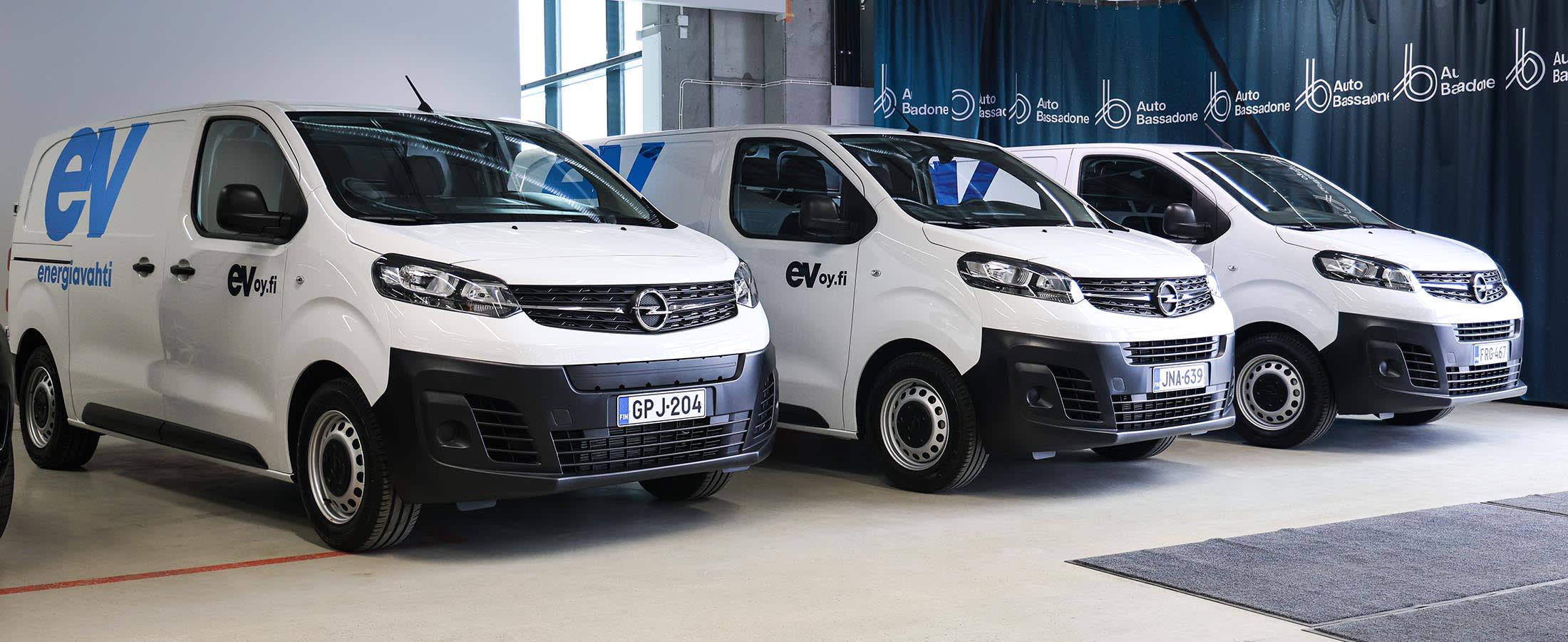 Kolme Opelin pakettiautoa rivissä. Autoissa on Energiavahdin teippaukset