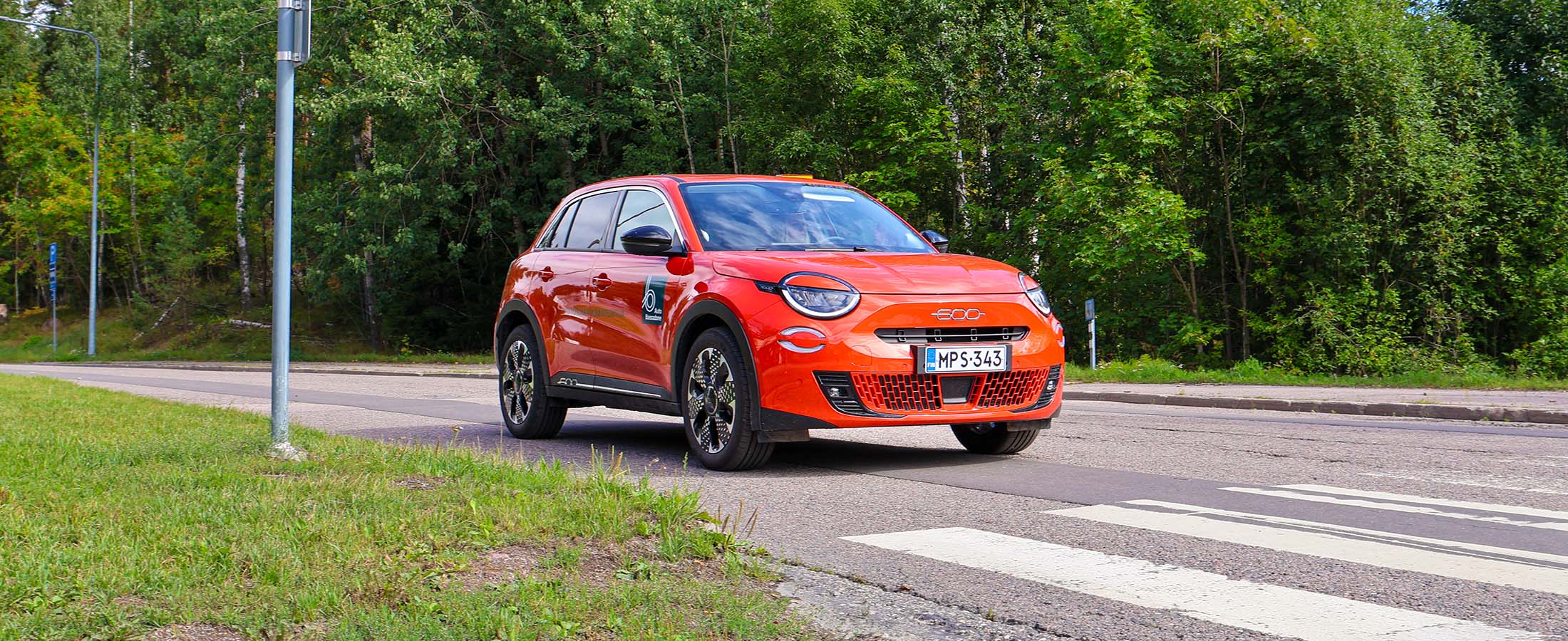 Oranssi Fiat 600 suojatien edessä