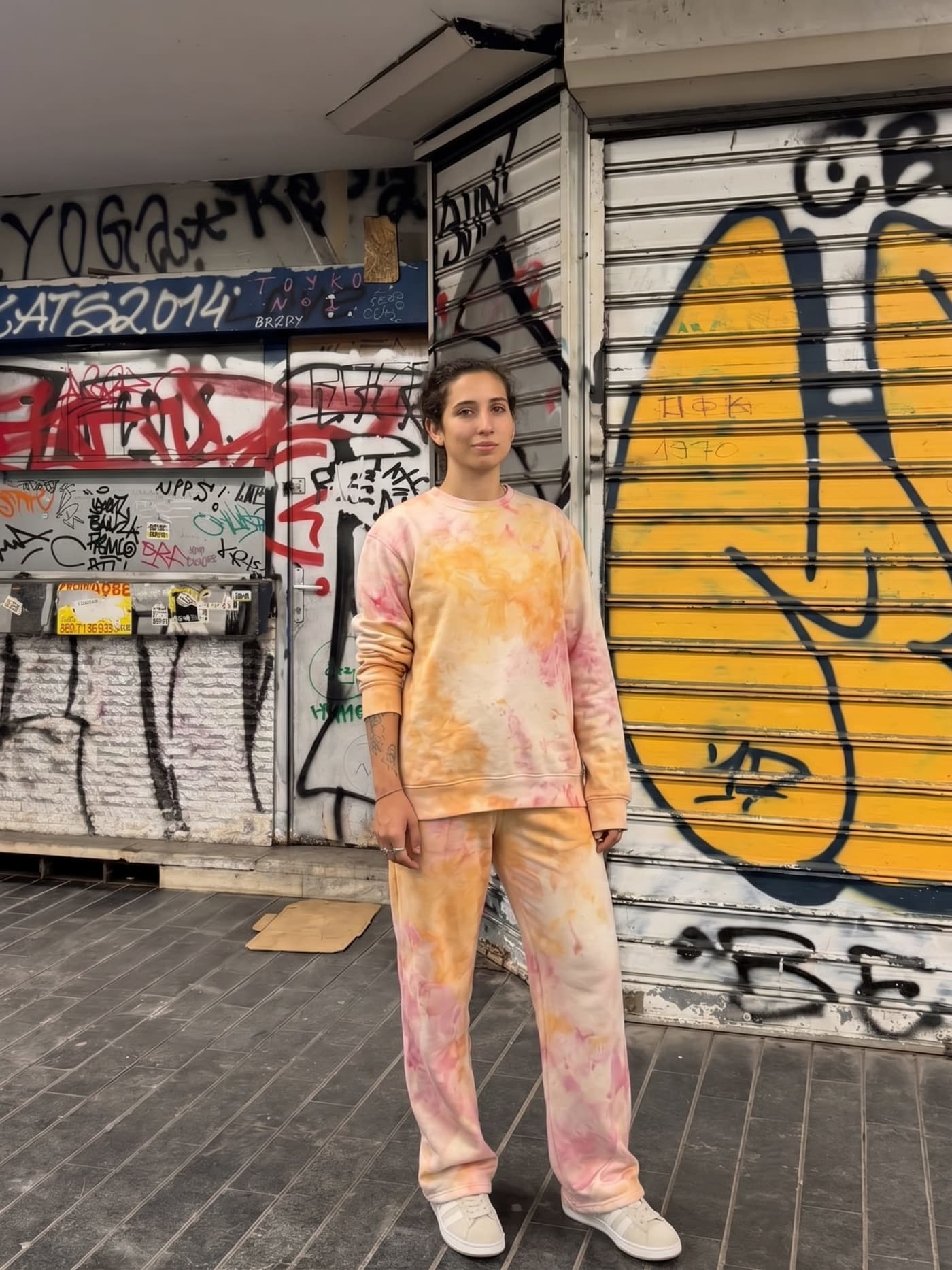 The sweatpants in Kafana, worn against a shuttered storefront.