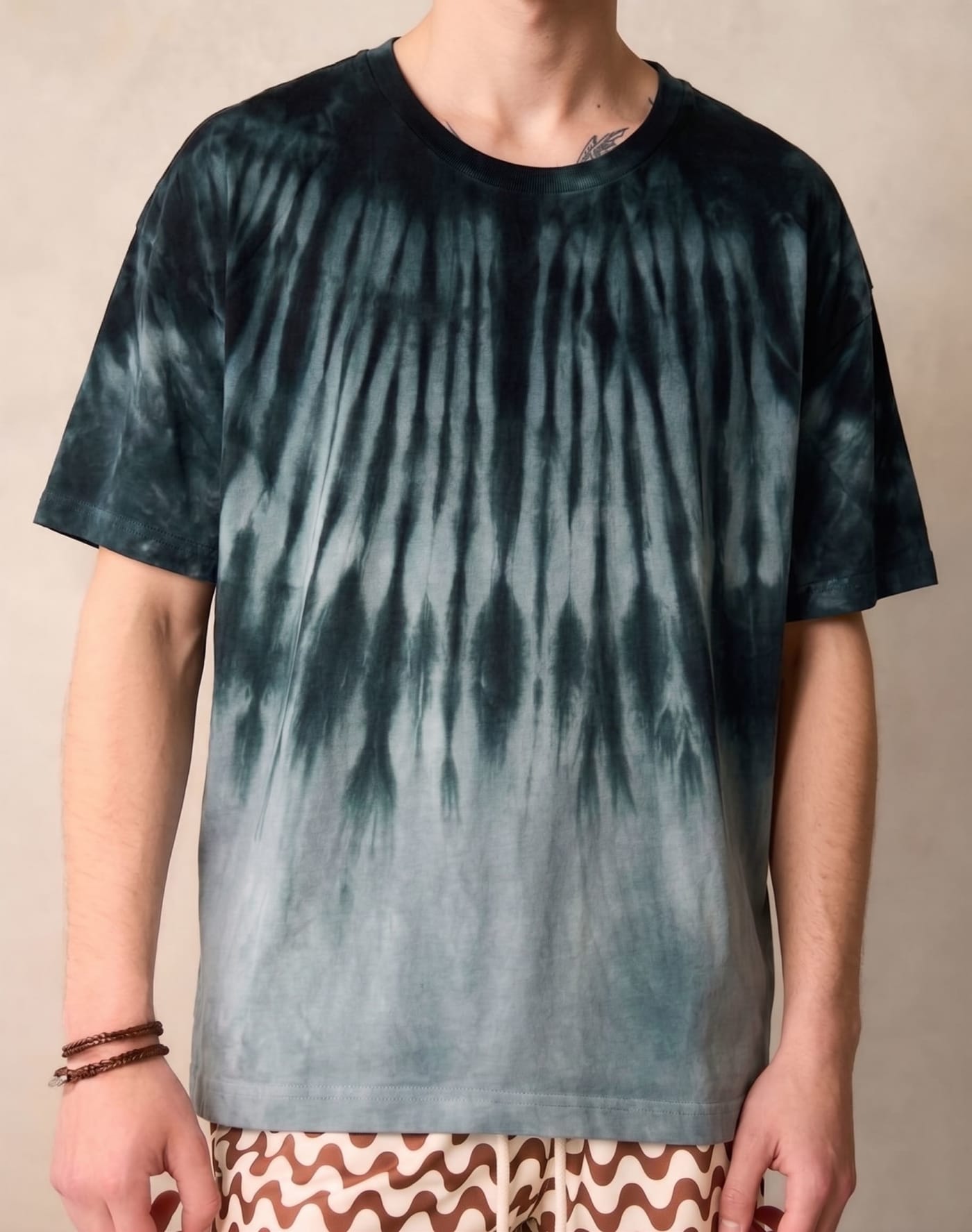 The heavyweight tee in Blok, worn — dark green breaking to grey.