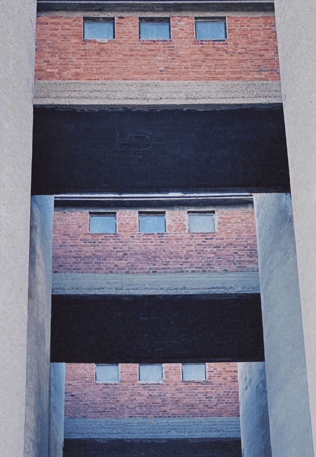Brick and concrete stacked in a lightwell, looking up.