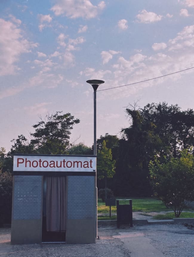 A photo booth in a park at dusk.