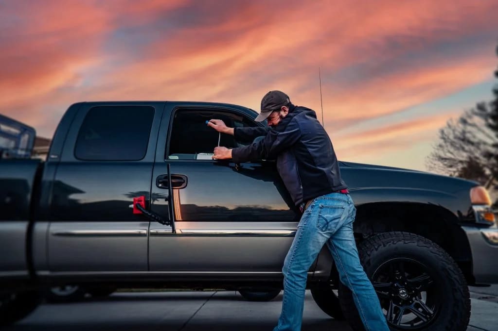 Kevin removing a dent from a truck at sunset
