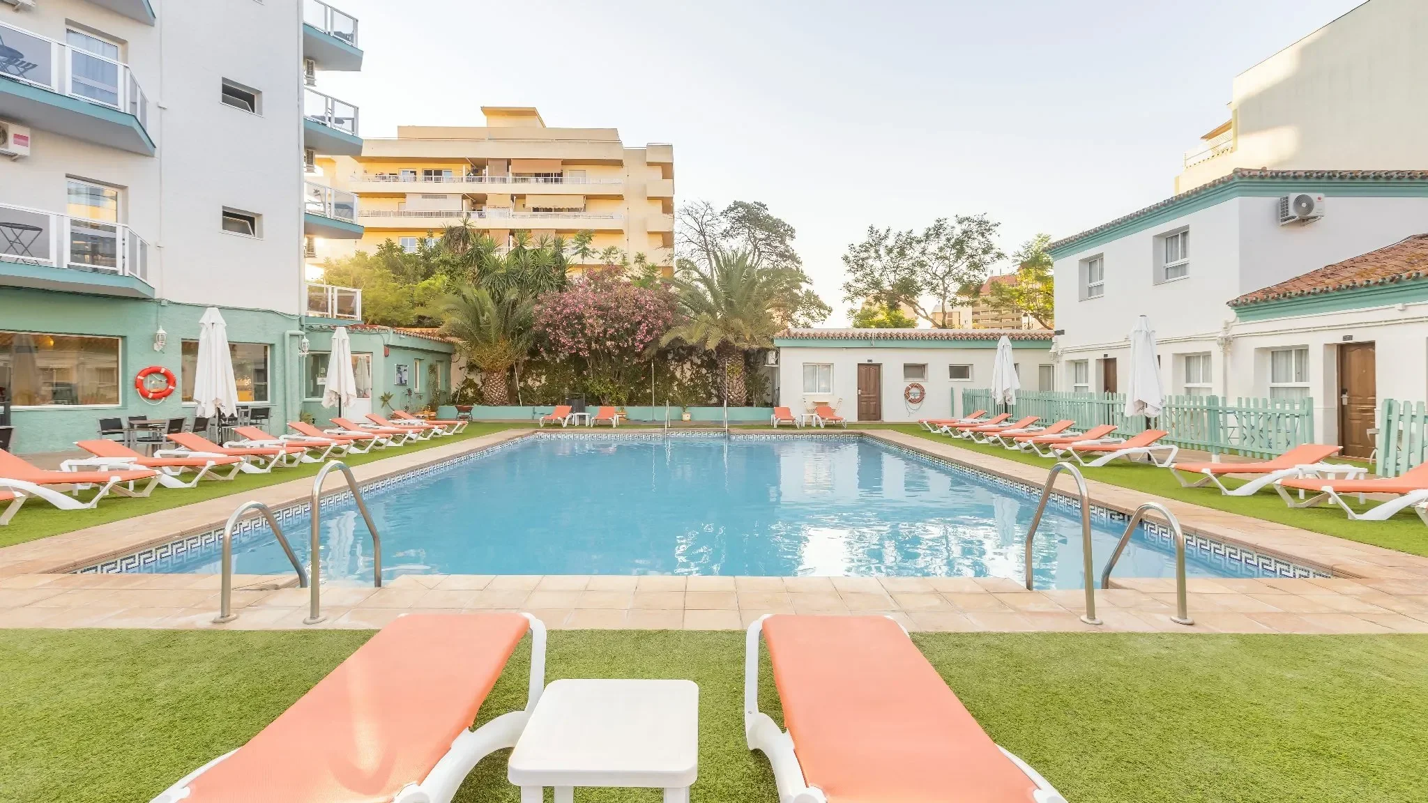 Piscina exterior del hotel rodeada de palmeras