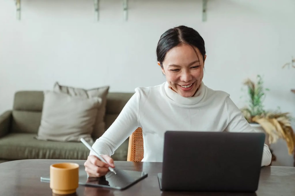 Woman smiling and looking at her laptop