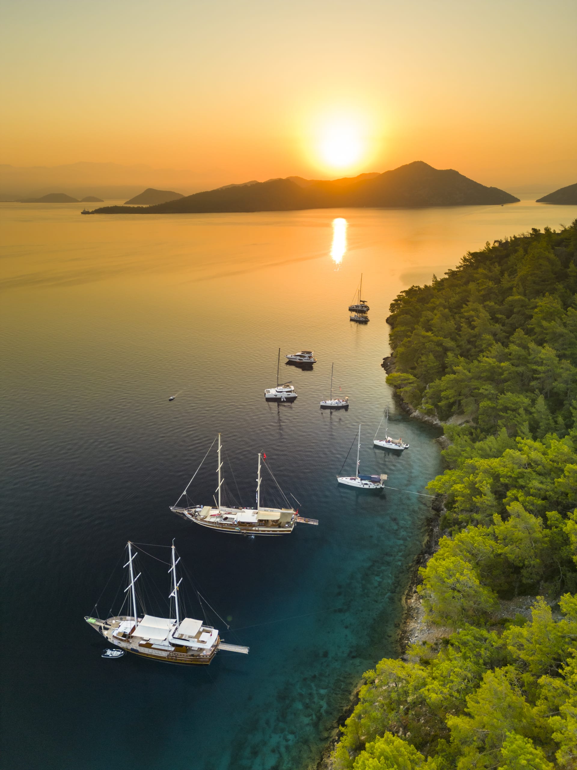 sunrise and sunset in a bay with yachts on the Mediterranean sea
with turquoise clear water