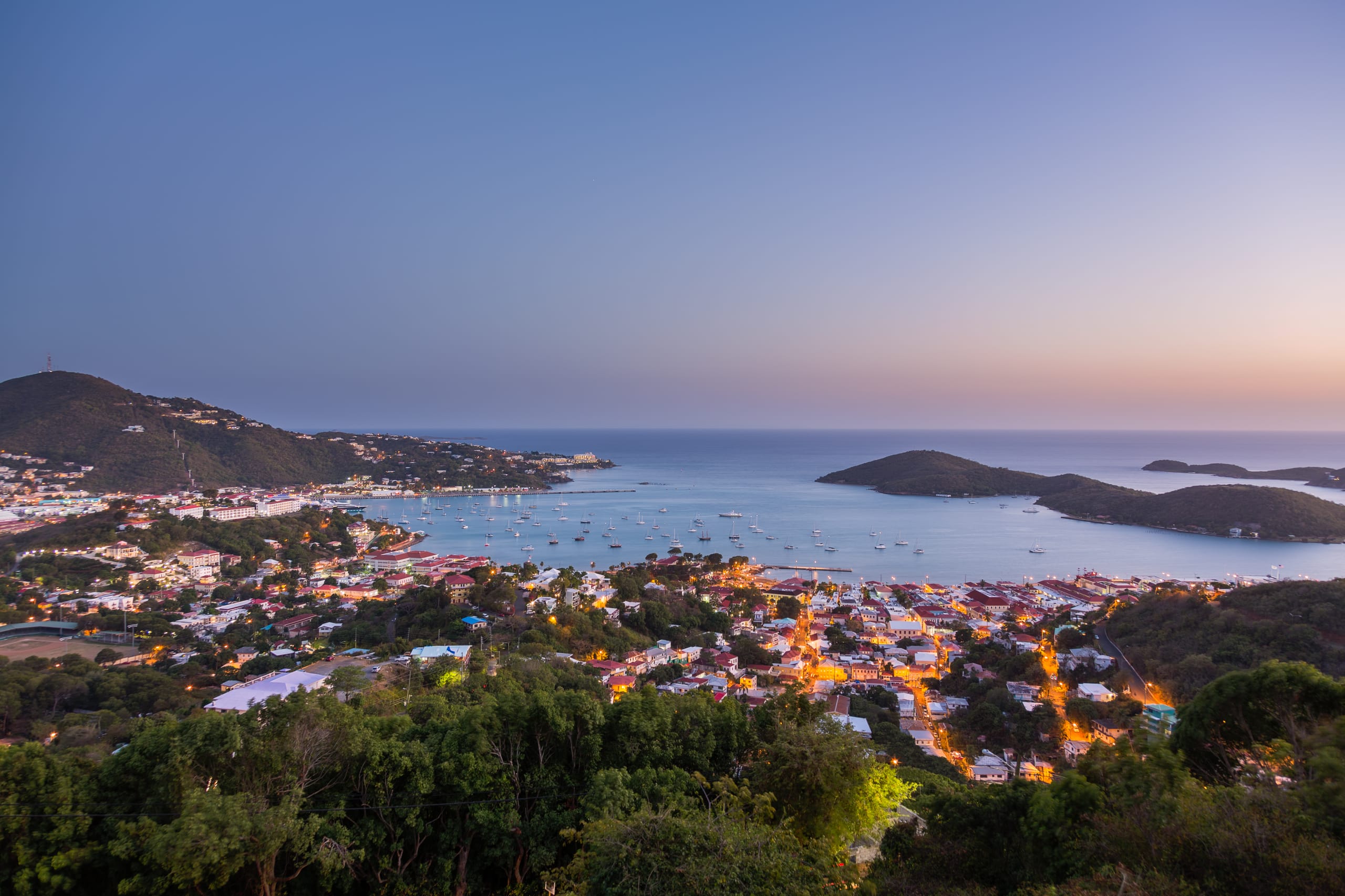 Sunset over the harbor of Charlotte Amalie in St Thomas with view over town and yachts in bay