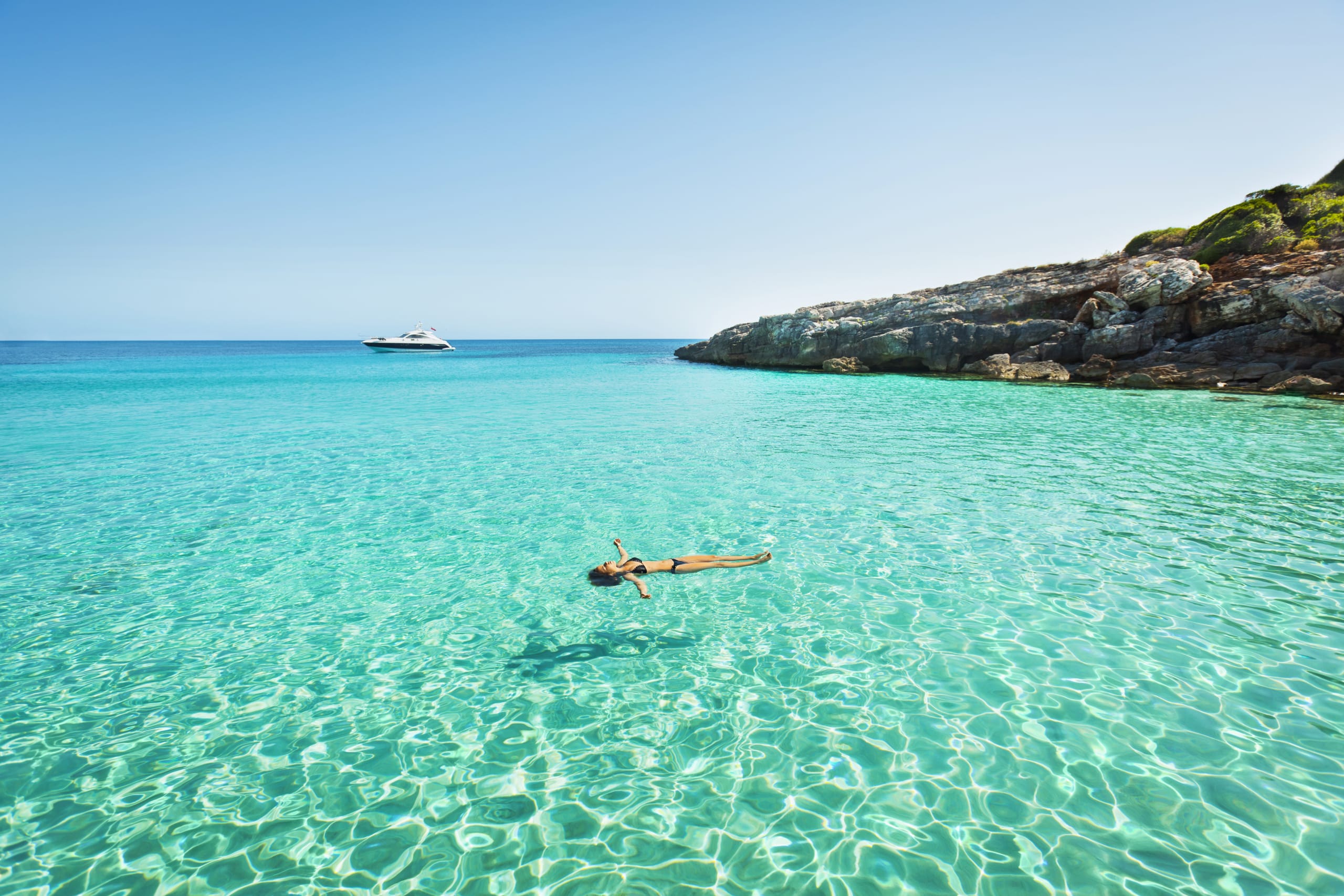 Idyllic holidays: girl floating in fresh clean turquoise water.