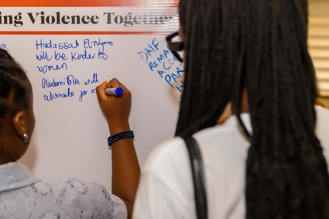Participants signing and displaying their public pledges at the dialogue