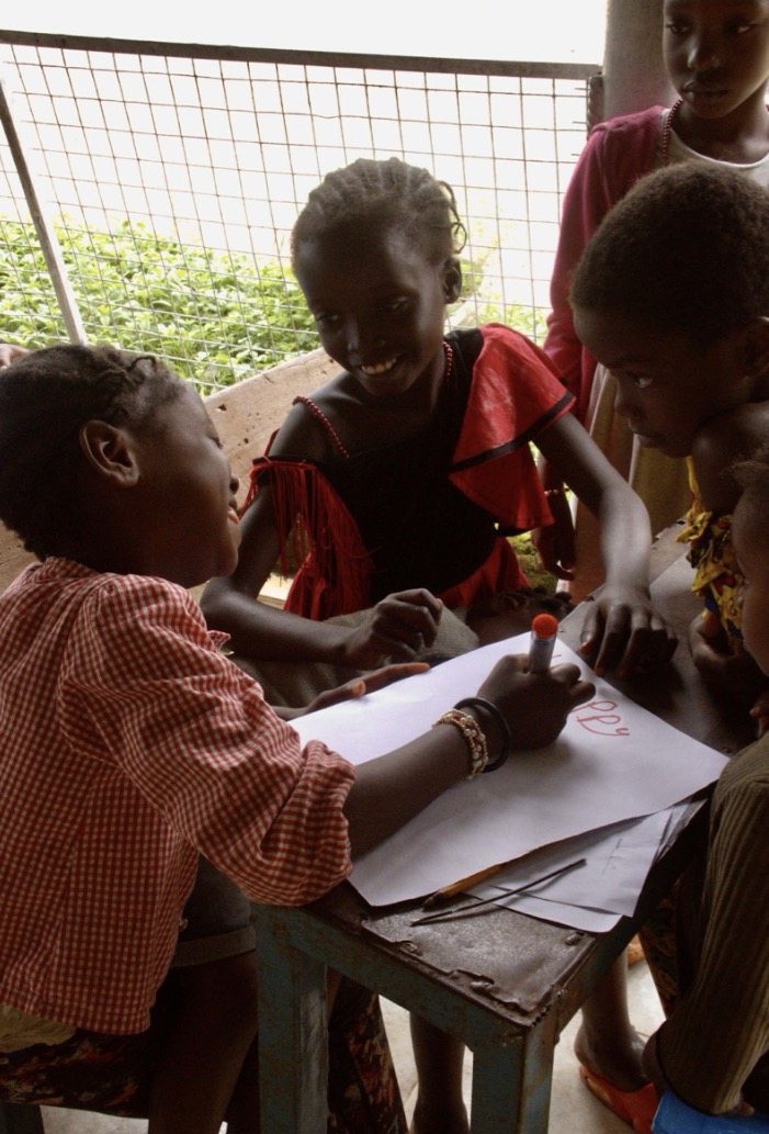 Facilitators using flipcharts and cardboard boards with children