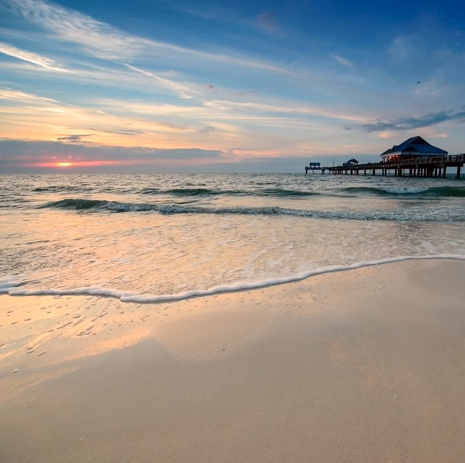 pier on beach at sunset