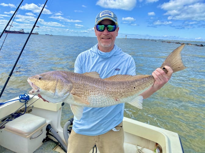 A handsome man holding a bull Redfish