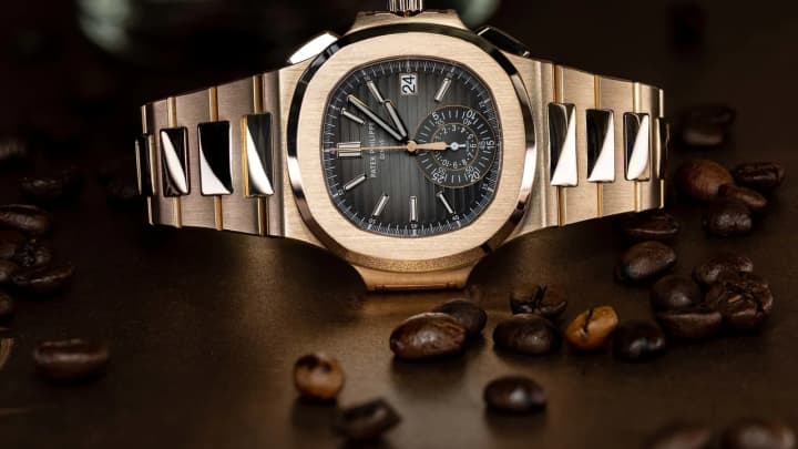Patek Philippe Nautilus rose gold on textured wood at golden hour