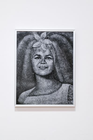 Colour photo of a woman's portrait that has been laser-etched into black granite